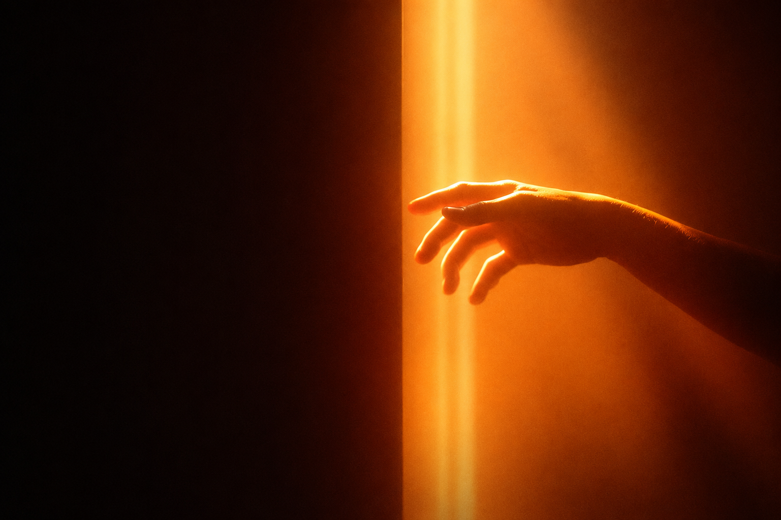 A hand reaching into warm light